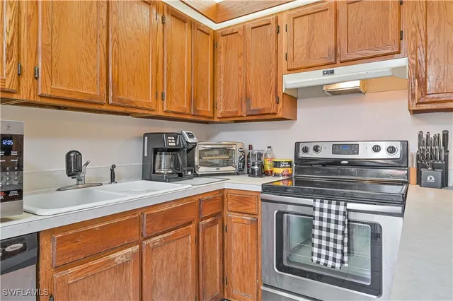 a kitchen with stainless steel appliances granite countertop a sink stove and cabinets