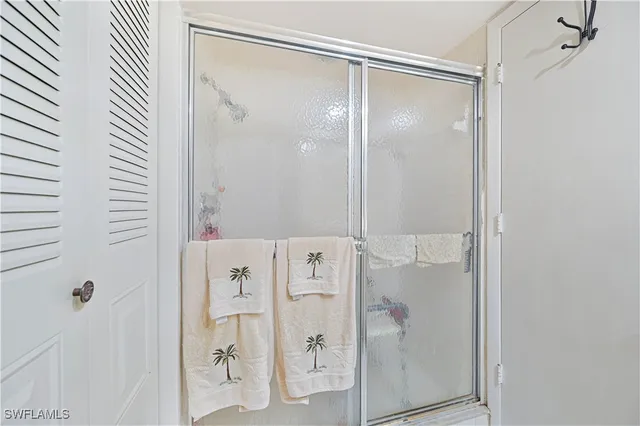 a bathroom with a glass shower door and a mirror