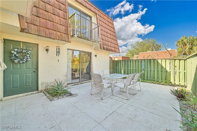 a view of a patio with couches table and chairs and potted plants