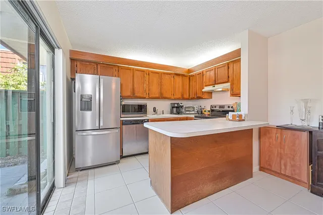 a kitchen with stainless steel appliances granite countertop a refrigerator sink and cabinets