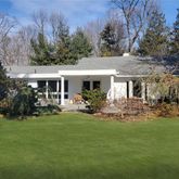 a view of a house with backyard garden and sitting area