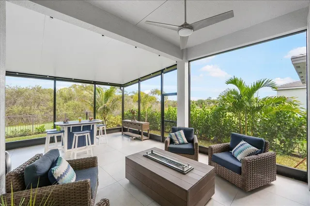a living room with furniture and a floor to ceiling window