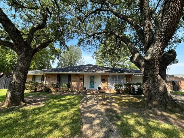 a view of a yard with table and chairs under an umbrella