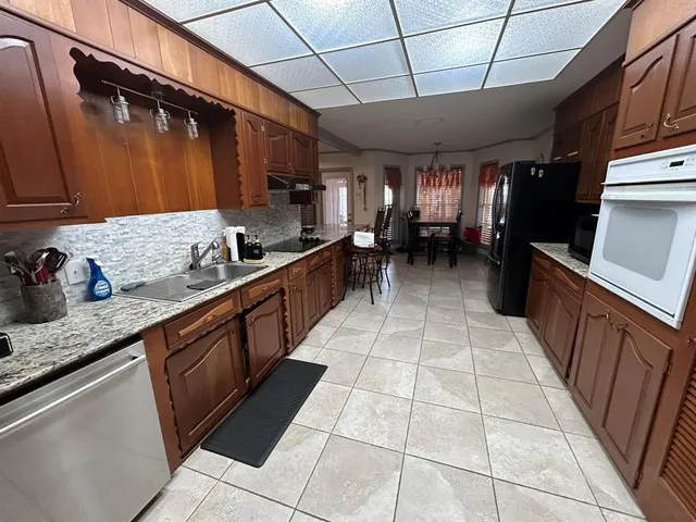 a kitchen with stainless steel appliances granite countertop a sink stove and cabinets