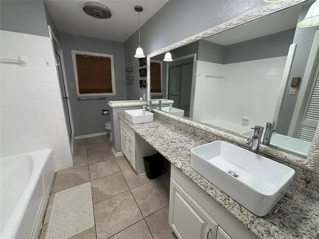 a spacious bathroom with a granite countertop sink and a mirror