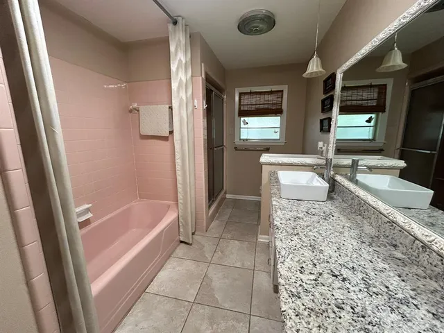 a bathroom with a granite countertop sink a toilet and bathtub