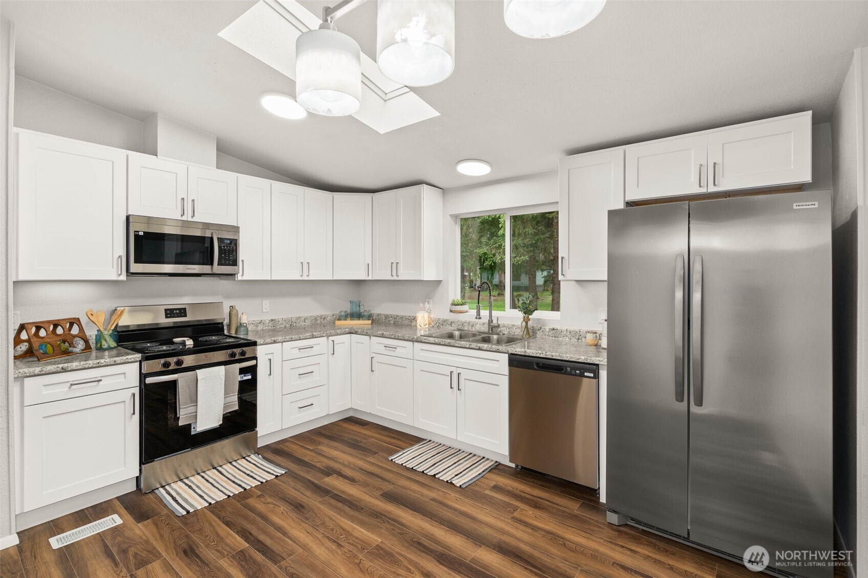 17340 Sargent Road Southwest, Unit 17 Rochester, WA 98579 - Photo 6 of 23 a kitchen with a sink stainless steel appliances and white cabinets