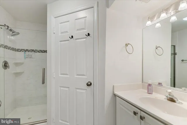 a bathroom with a sink vanity granite shower and a mirror