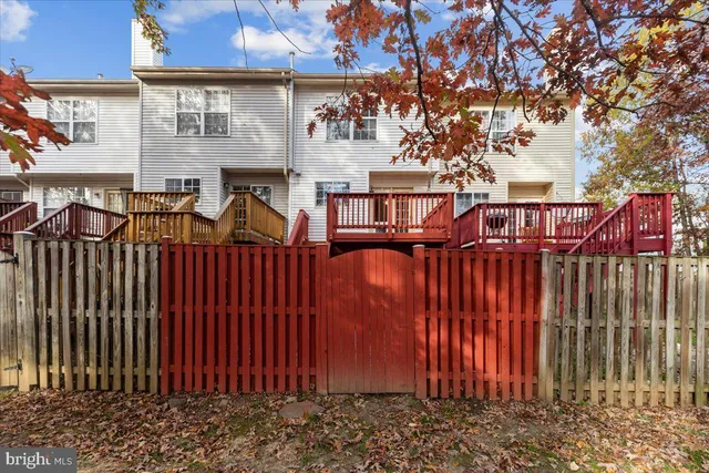 a view of a brick house with wooden fence