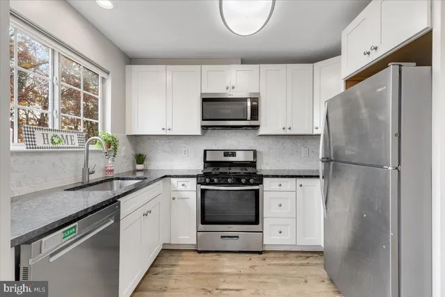 a kitchen with a stove a refrigerator and a sink