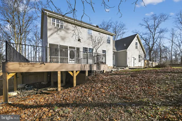 a view of a white house with a large tree next to a yard