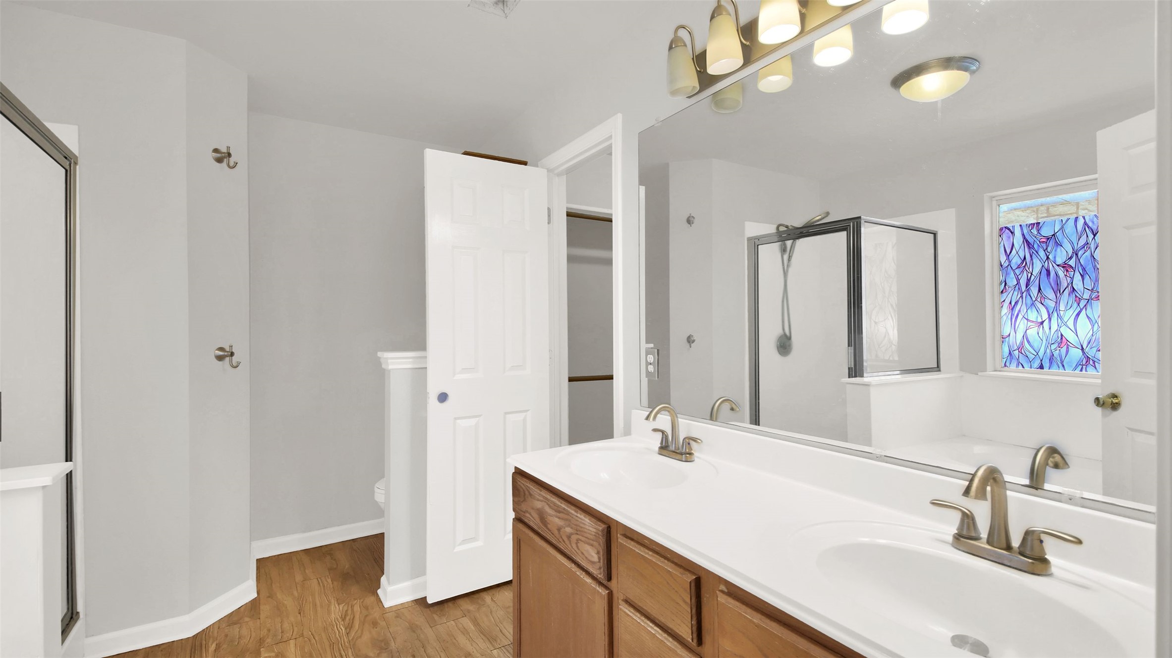 1609 Harness Raceway Street Pflugerville, TX 78660 - Photo 26 of 32 Double vanity sinks and a glass-enclosed shower create a practical bathroom space.