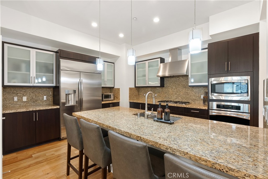21 Gramercy, Unit 102 Irvine, CA 92612 - Photo 7 of 30 Beautifully updated kitchen with rich cabinetry, stone countertops, and generous prep space.