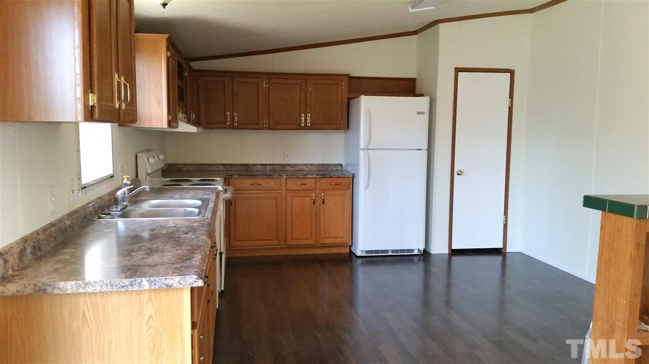 4815 Brown Road Rougemont, NC 27572 - Photo 7 of 23 a kitchen with stainless steel appliances granite countertop a refrigerator a stove and a wooden floors