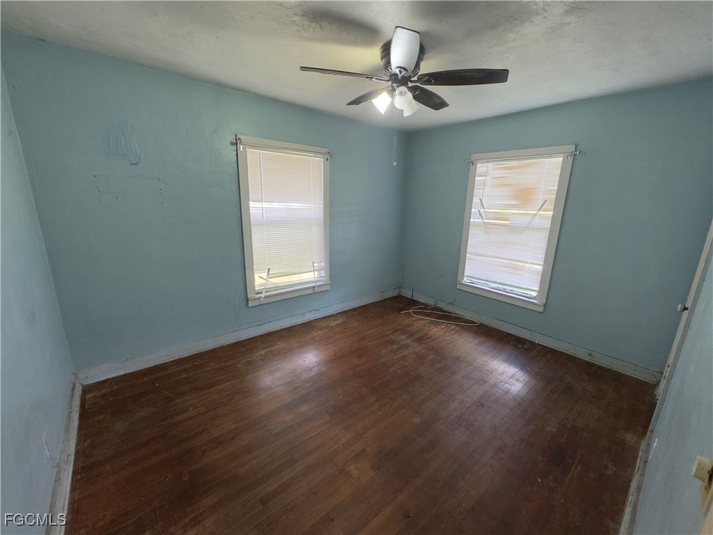 508 East Ventura Avenue Clewiston, FL 33440 - Photo 6 of 14 wooden floor in an empty room with a window