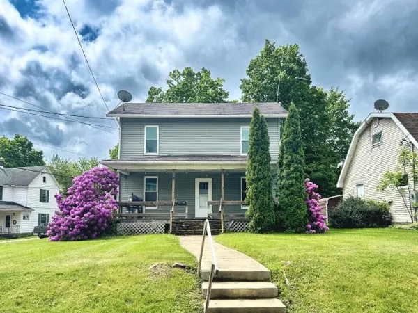 a view of a house with table and chairs in front of a house
