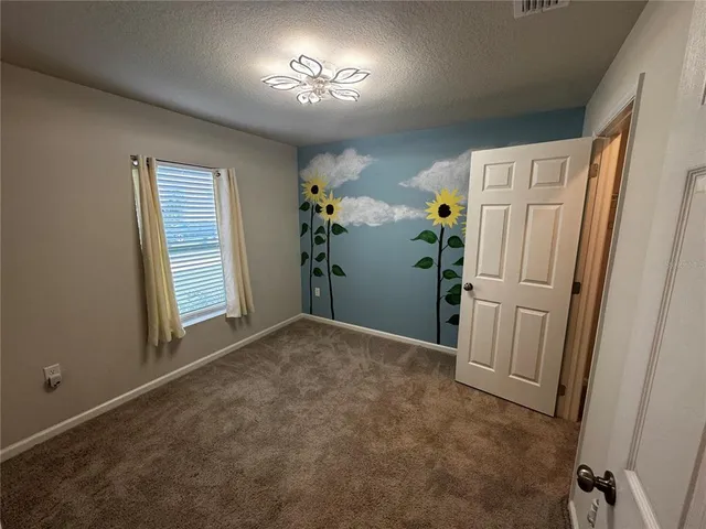 a view of empty room with a window and hardwood