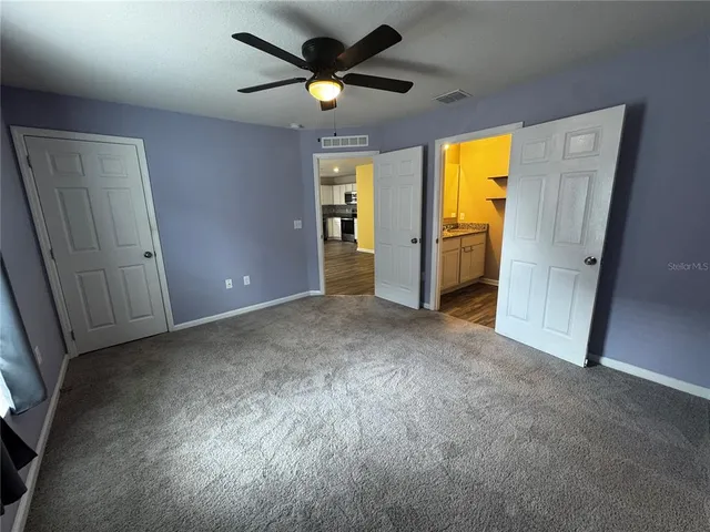 a view of empty room with a ceiling fan and window