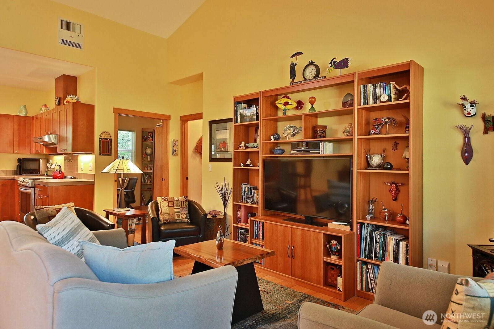 1050 Village Loop Langley, WA 98260 - Photo 19 of 39 a living room with furniture a flat screen tv and a floor to ceiling window
