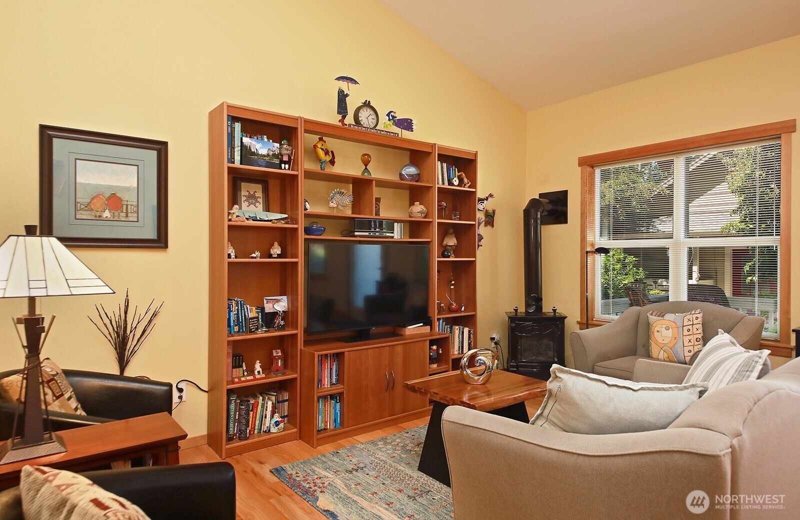 1050 Village Loop Langley, WA 98260 - Photo 20 of 39 a living room with furniture a flat screen tv and a floor to ceiling window