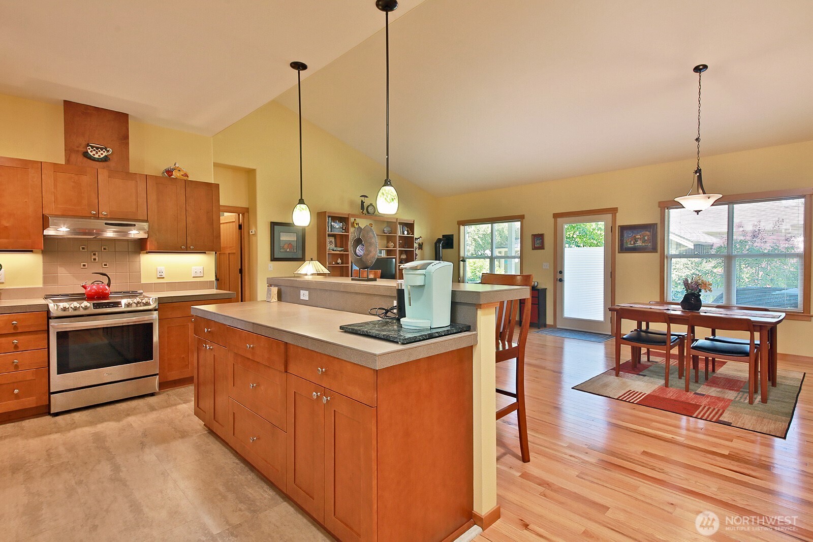 1050 Village Loop Langley, WA 98260 - Photo 26 of 39 a kitchen with stainless steel appliances granite countertop a stove a sink dishwasher and a dining table with the view of living room