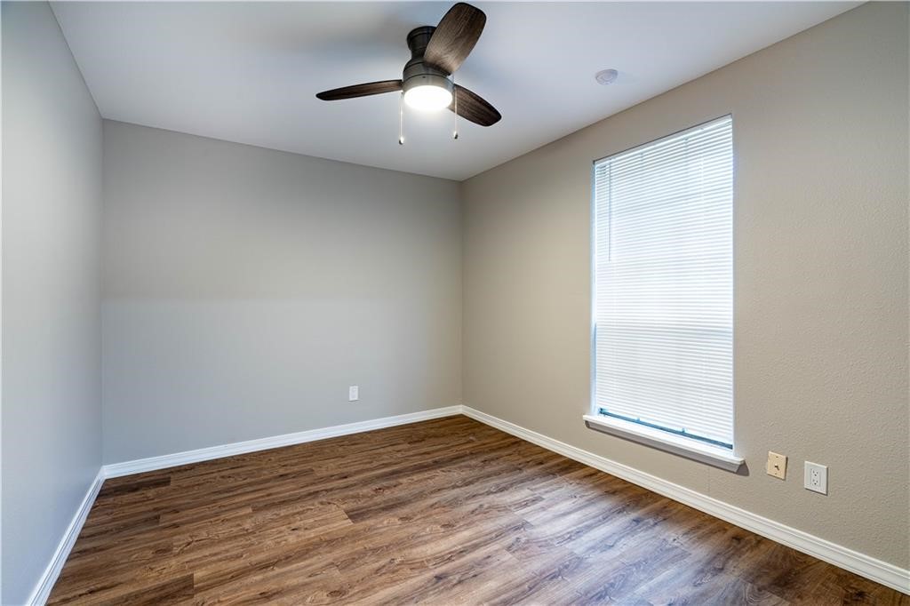 715 Bosquez Street Robstown, TX 78380 - Photo 12 of 18 a view of empty room with wooden floor and fan