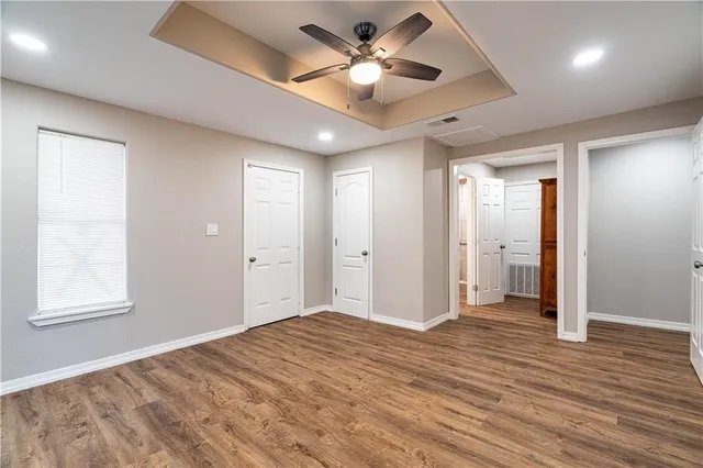 a view of a big room with wooden floor and a ceiling fan
