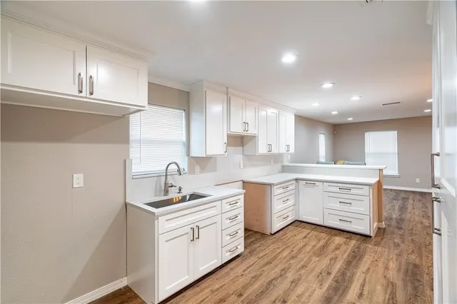 a kitchen with white cabinets sink and stove