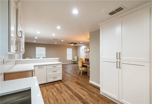 a large kitchen with a lot of counter space and wooden floor