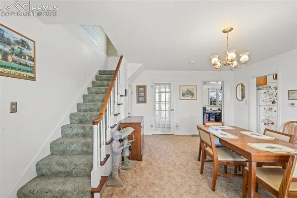 a view of a livingroom with furniture a chandelier and wooden floor