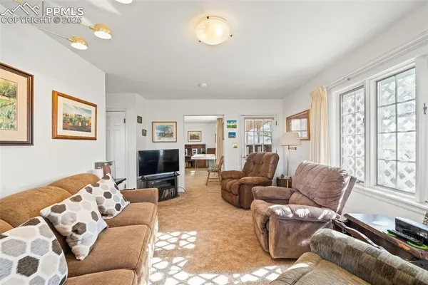 a living room with furniture large window and flat screen tv