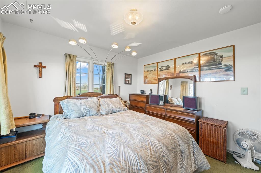 1805 West County Road 8 Berthoud, CO 80513 - Photo 33 of 48 a bedroom with a bed and wooden floor