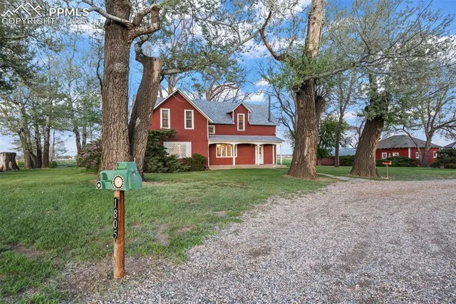 a front view of a house with a yard and tree