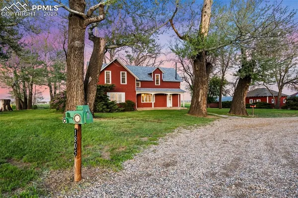 a front view of a house with a yard and trees