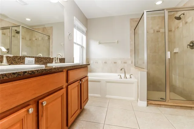 a bathroom with a tub sink shower and mirror