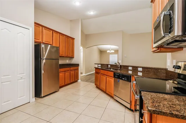 a kitchen with granite countertop a refrigerator and a stove top oven