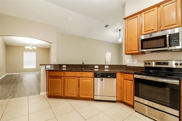 a kitchen with stainless steel appliances granite countertop a stove a sink and a microwave
