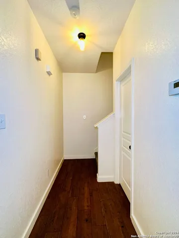 a view of a hallway with wooden floor