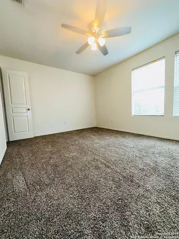 an empty room with a window and a ceiling fan