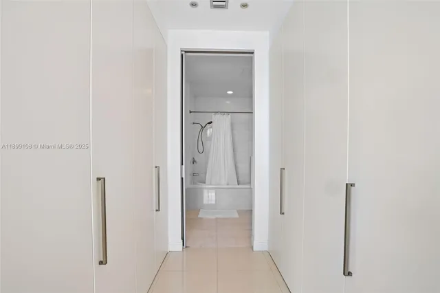 a view of a hallway with closet and mirror