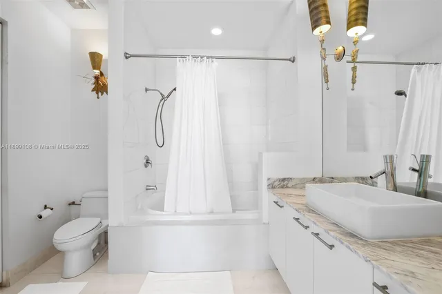 a bathroom with a granite countertop shower sink vanity mirror and toilet