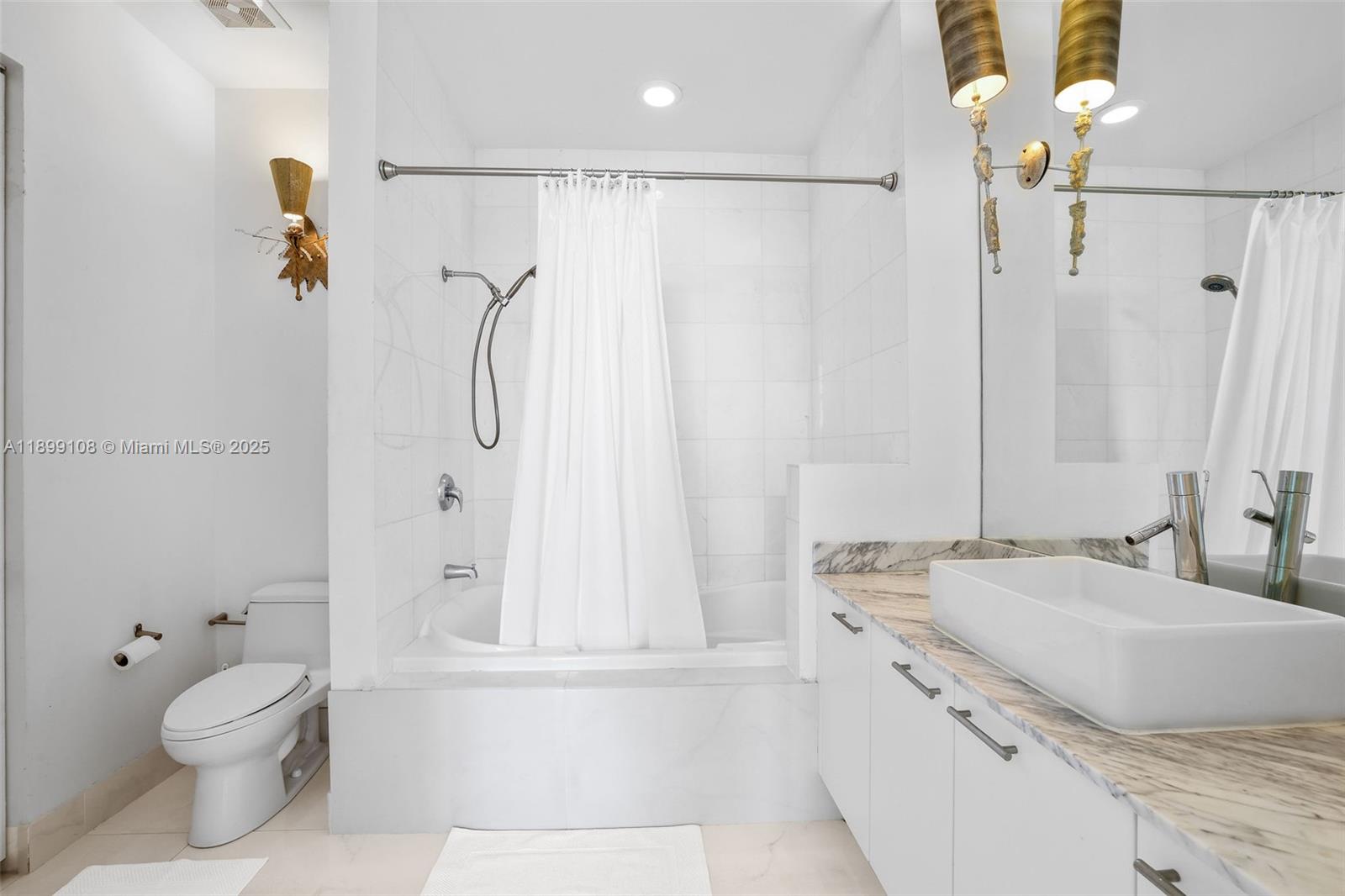 2001 Meridian Avenue, Unit 506 Miami Beach, FL 33139 - Photo 19 of 40 a bathroom with a granite countertop shower sink vanity mirror and toilet