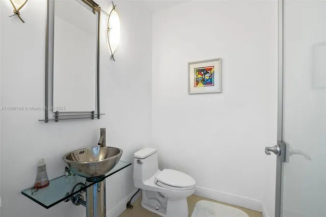 a bathroom with a sink a toilet and mirror