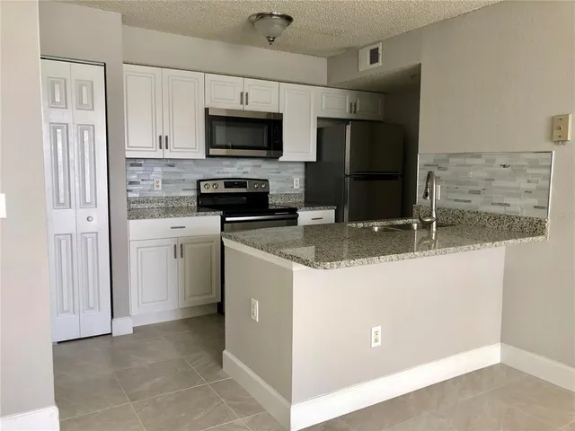 a kitchen with a refrigerator stove and microwave