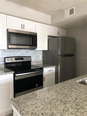 a kitchen with stainless steel appliances granite countertop a refrigerator stove and microwave