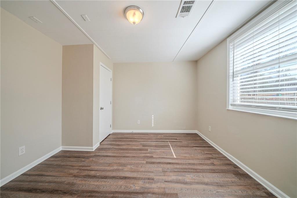 1433 Dennis Drive Decatur, GA 30032 - Photo 18 of 28 a view of an empty room with wooden floor and a window