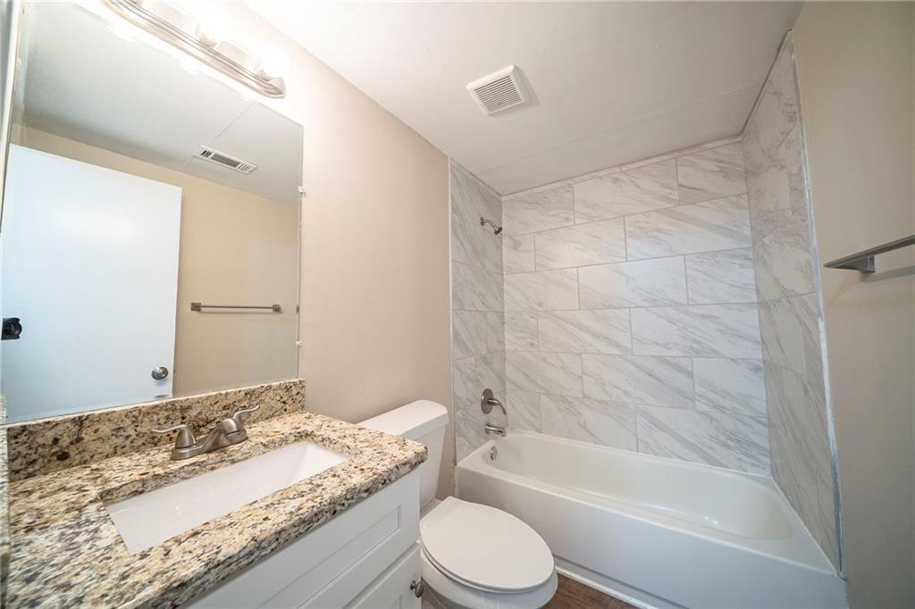 1433 Dennis Drive Decatur, GA 30032 - Photo 21 of 28 a bathroom with a granite countertop bathtub shower sink vanity and toilet