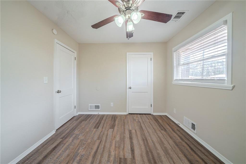 1433 Dennis Drive Decatur, GA 30032 - Photo 8 of 28 an empty room with wooden floor chandelier fan and windows