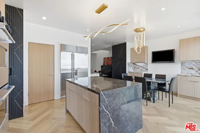 a kitchen with stainless steel appliances granite countertop a sink a stove and a refrigerator