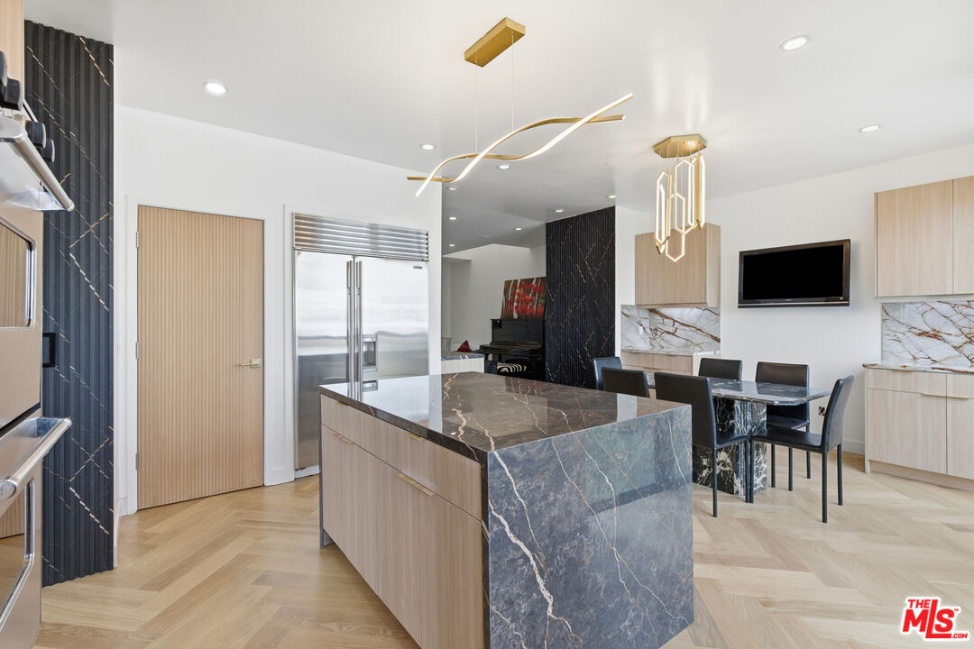 121 South Canon Drive, Unit PH 401 Beverly Hills, CA 90212 - Photo 11 of 31 a kitchen with stainless steel appliances granite countertop a sink a stove and a refrigerator